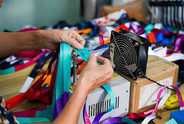 Worker Cutting and Sealing Lanyards with Heat Machine